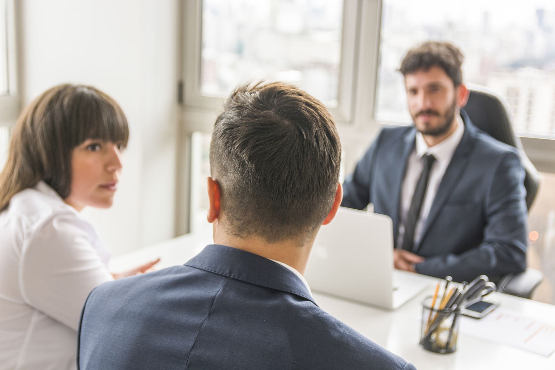 empresario-y-empresaria-sentado-frente-gerente-en-el-lugar-de-trabajo (1) (1)